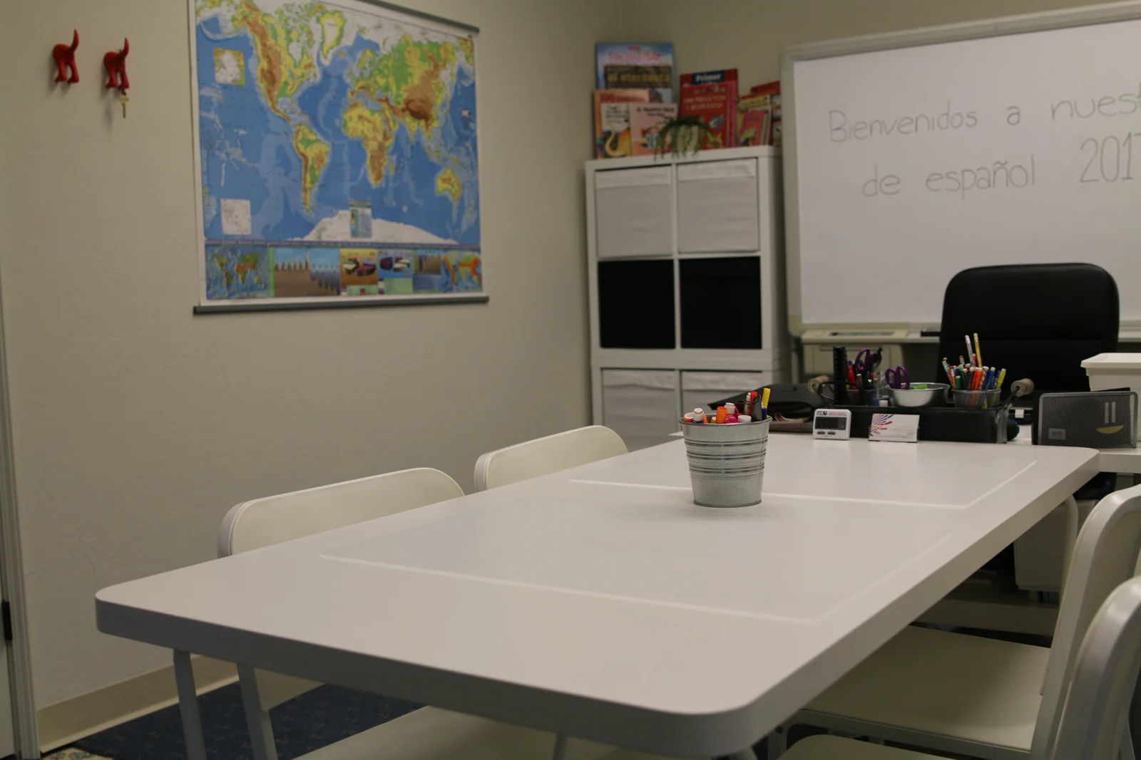 Small-group learning table with a world map and whiteboard